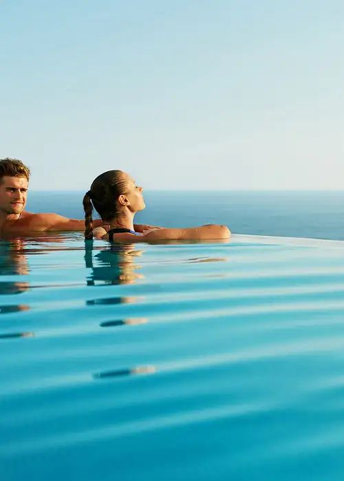 A Couple in a pool looking out over the ocean