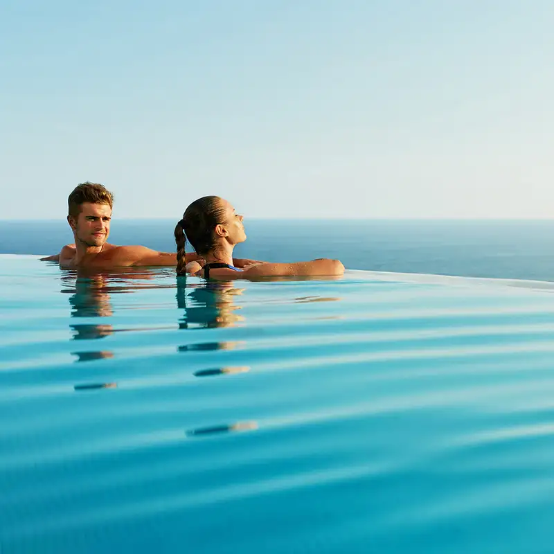 A Couple in a pool looking out over the ocean
