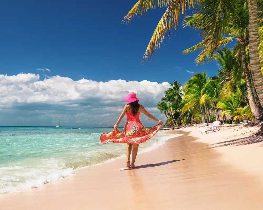 A woman walking down a caribbean beach