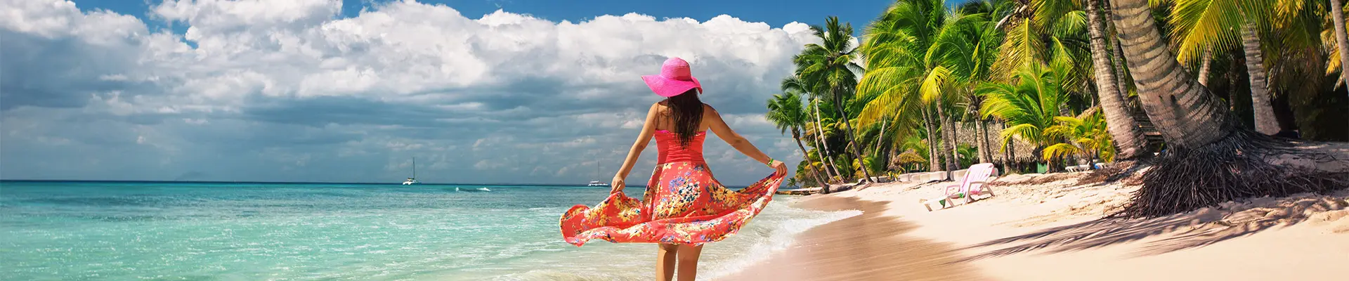 A woman walking down a caribbean beach