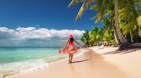 A woman walking down a caribbean beach