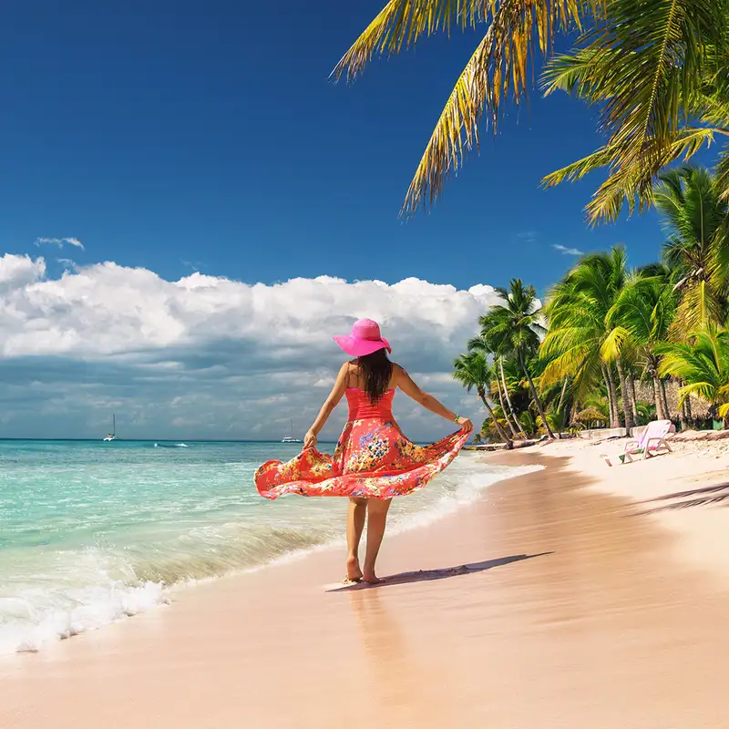 A woman walking down a caribbean beach