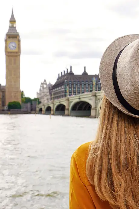 A woman looking over the River Thames, at Big Ben