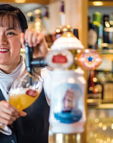 A bartender pouring a drink on a Fred Olsen Ship