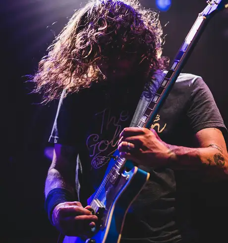 A man playing an electric guitar at a concert