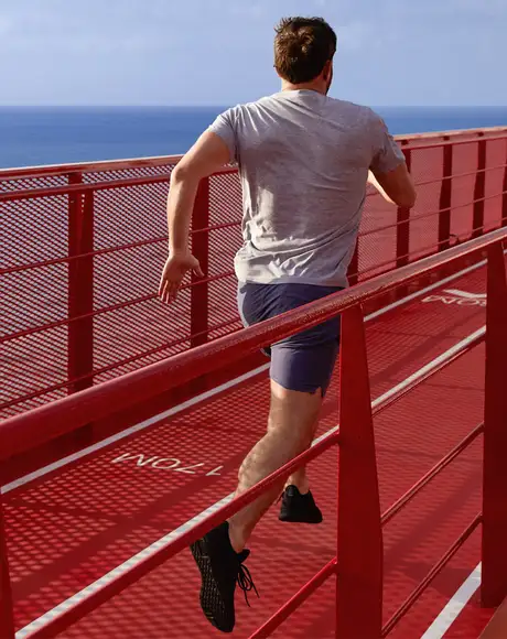 A Man running on a Running track on a Virgin Voyages Ship