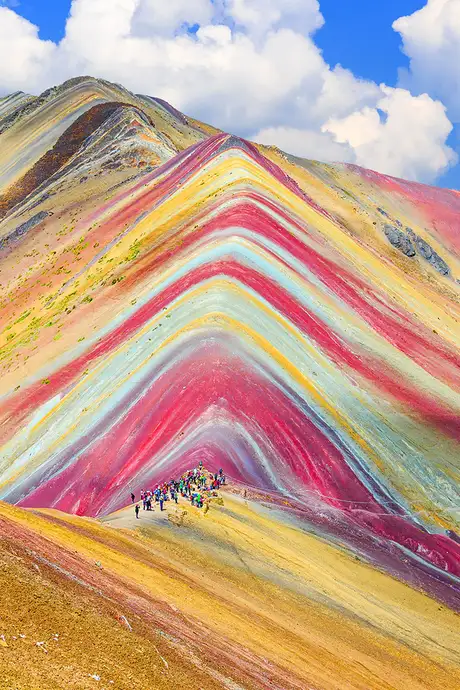 An image of Rainbow Mountain in Peru, With a group of mountain climbers making their way up