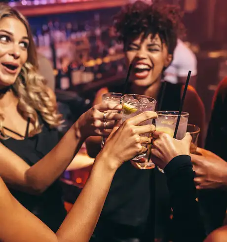 A group of friends cheering drinks in a bar