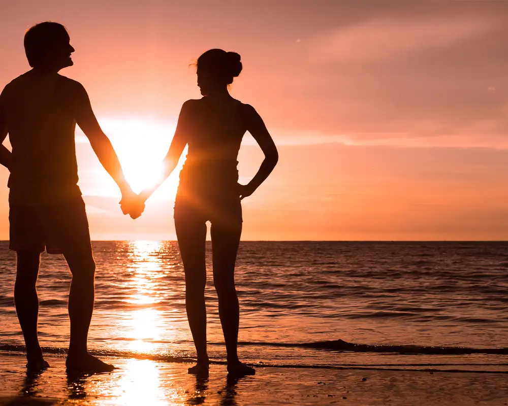 A couple watching a sunset at the beach