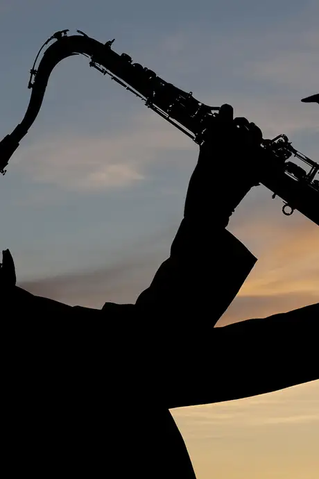 A silhouette of a man playing a saxophone