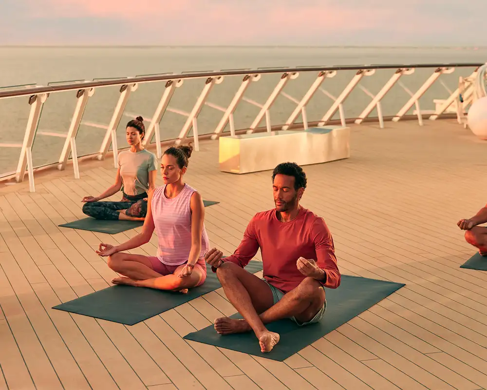 A group of people taking part in a yoga class aboard a Celebrity Ship