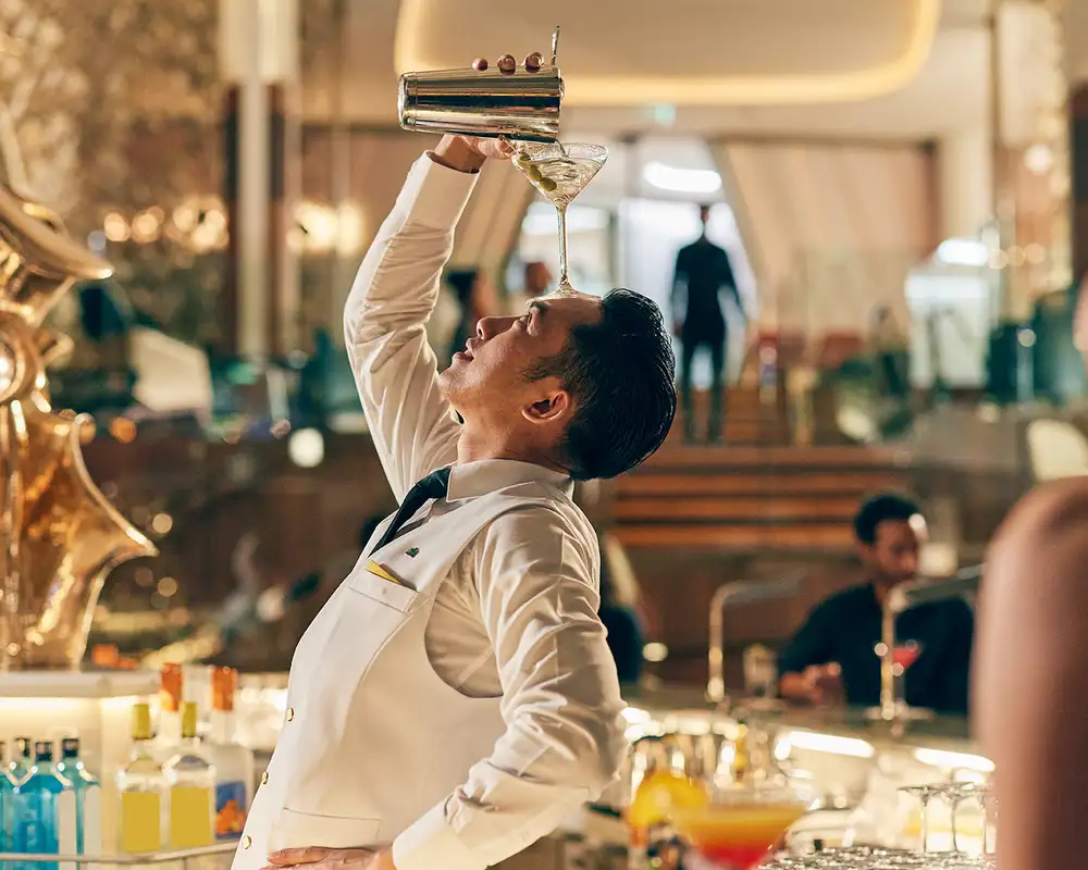 A Bartender showing off while making a drink aboard a Celebrity ship