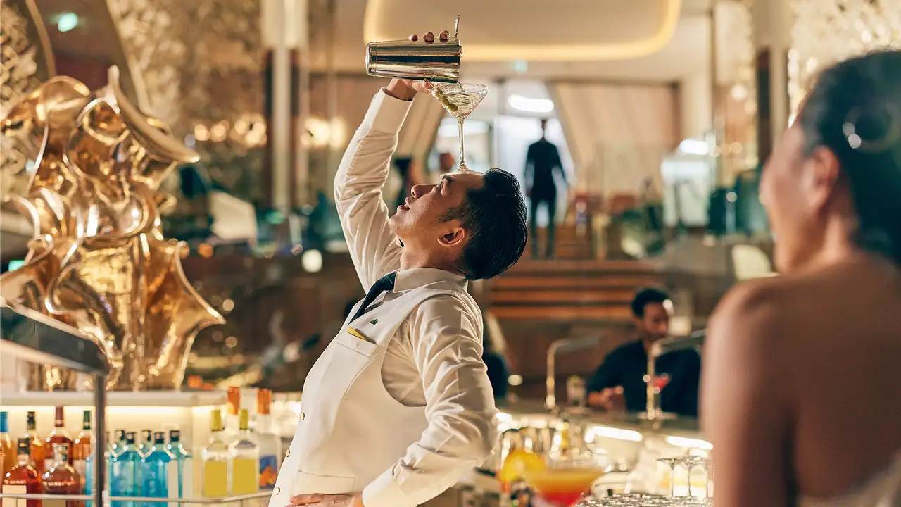 A Bartender showing off while making a drink aboard a Celebrity ship