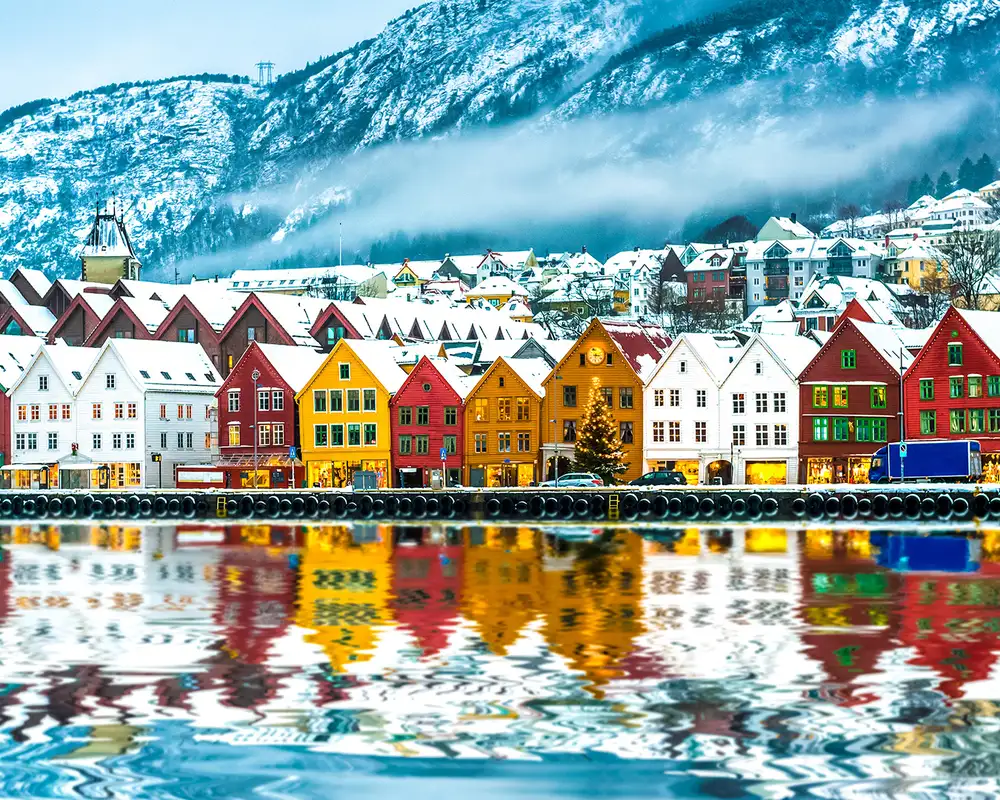 A row of Snow Covered Houses on a river bank in Bergen
