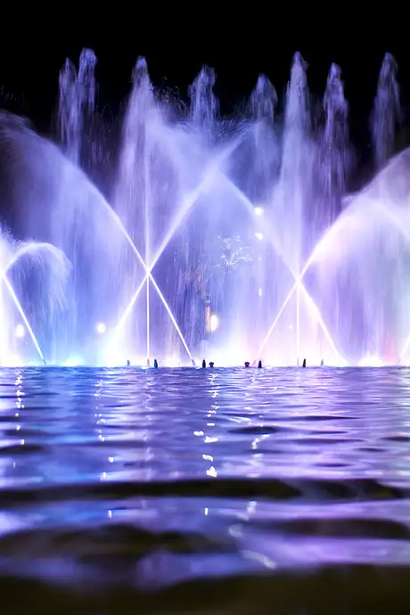 A fountain show being lit up by blue and purple lights in Salou, Spain
