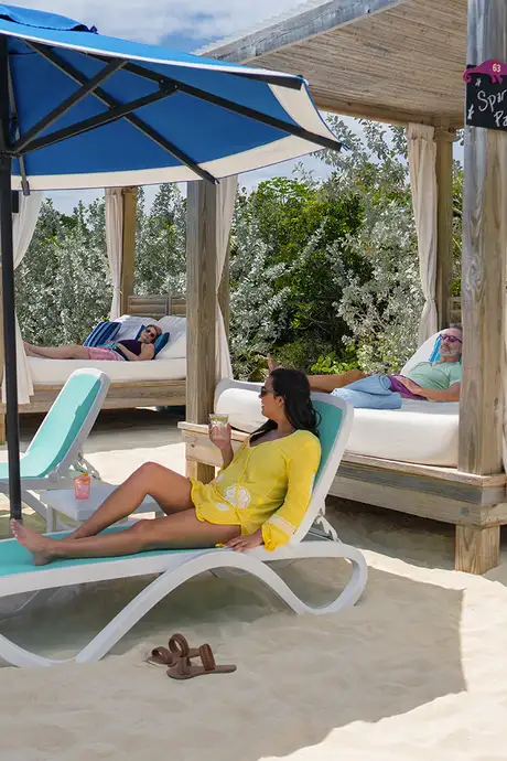 Two groups of people relaxing on the beach as a part of Coco Beach Club on Cococay