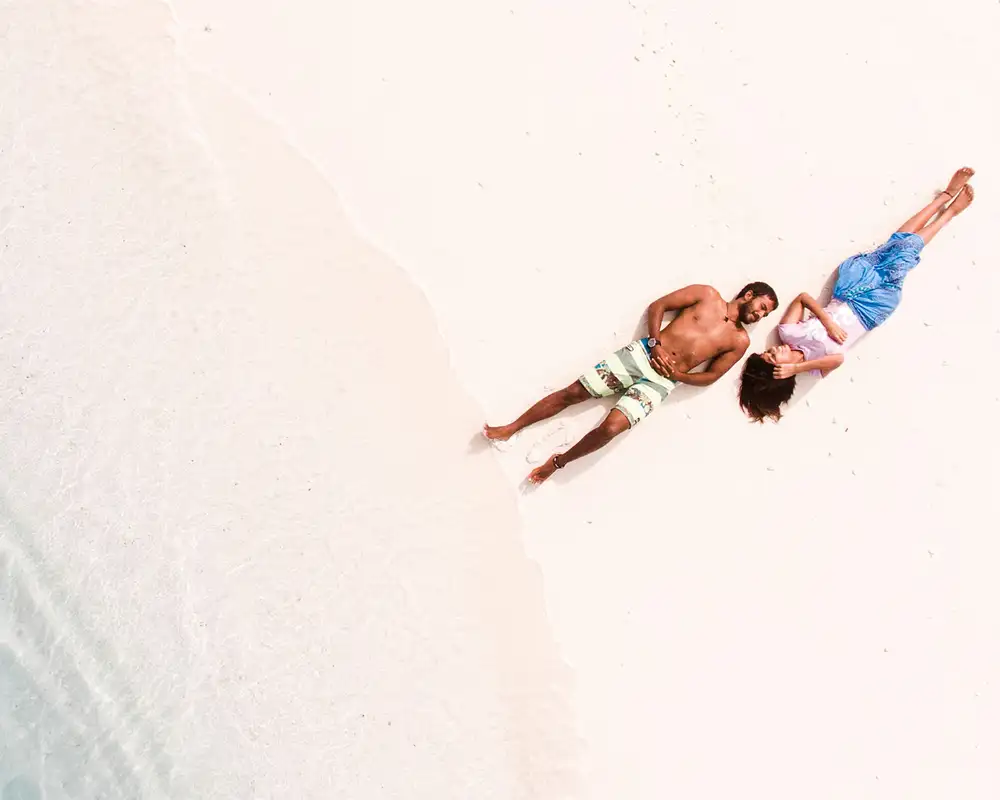 A couple lying down on a beach