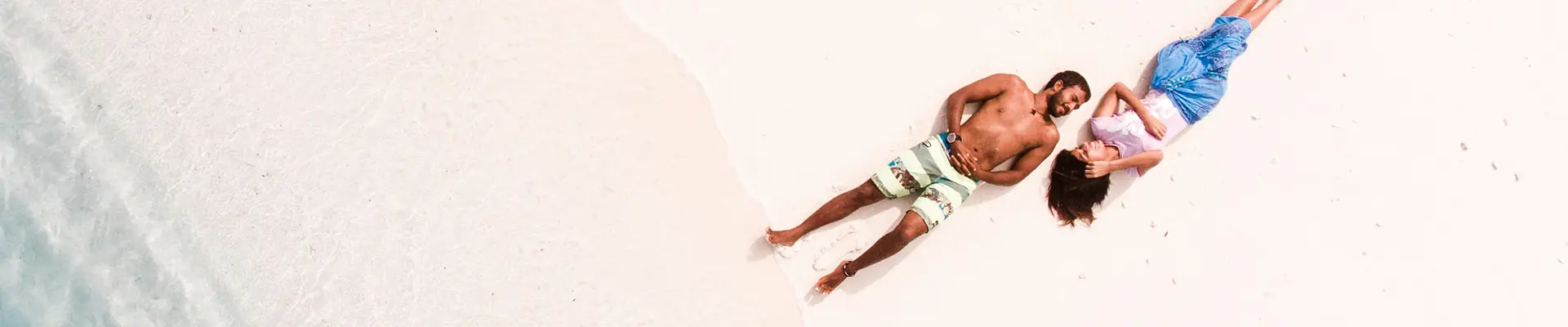 A couple lying down on a beach