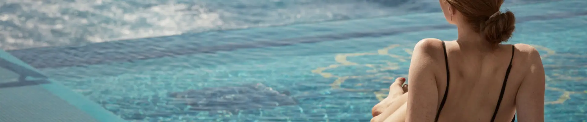 A Woman Relaxing on a sun chair by a pool