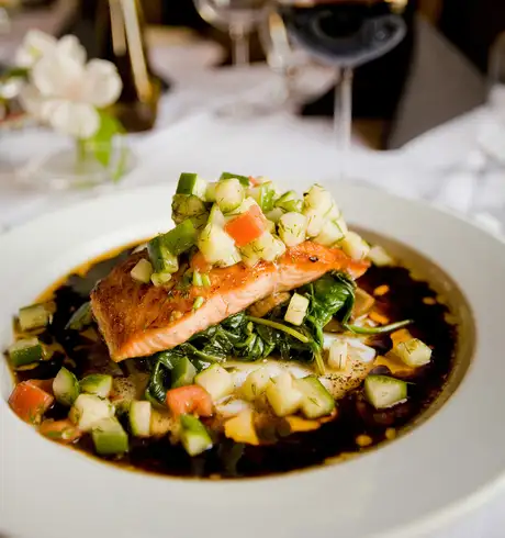 A serving of Salmon, vegetables and a sauce