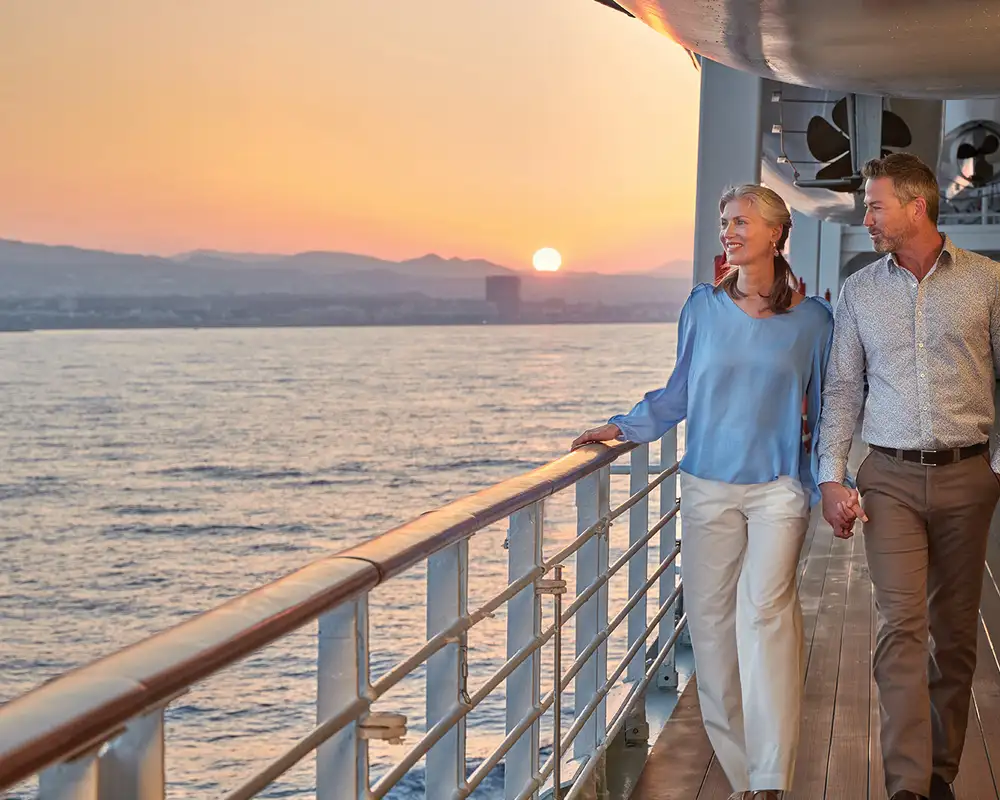 A Couple looking out over a railing on an Oceania Cruise Ship