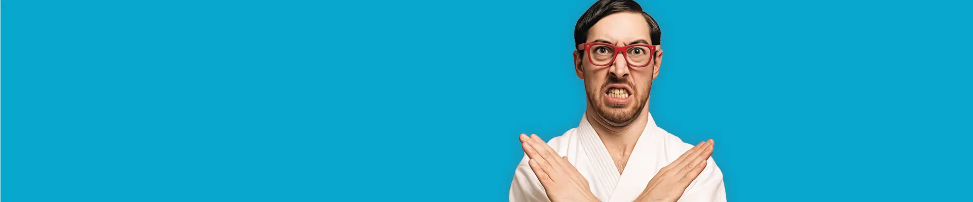 Man in a white robe and red glasses making an "X" with arms against a blue background.