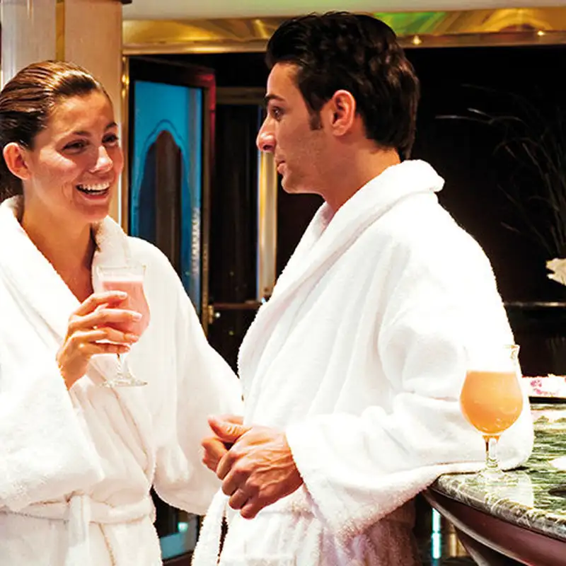 A Couple having drinks while wearing white bathrobes in a spa