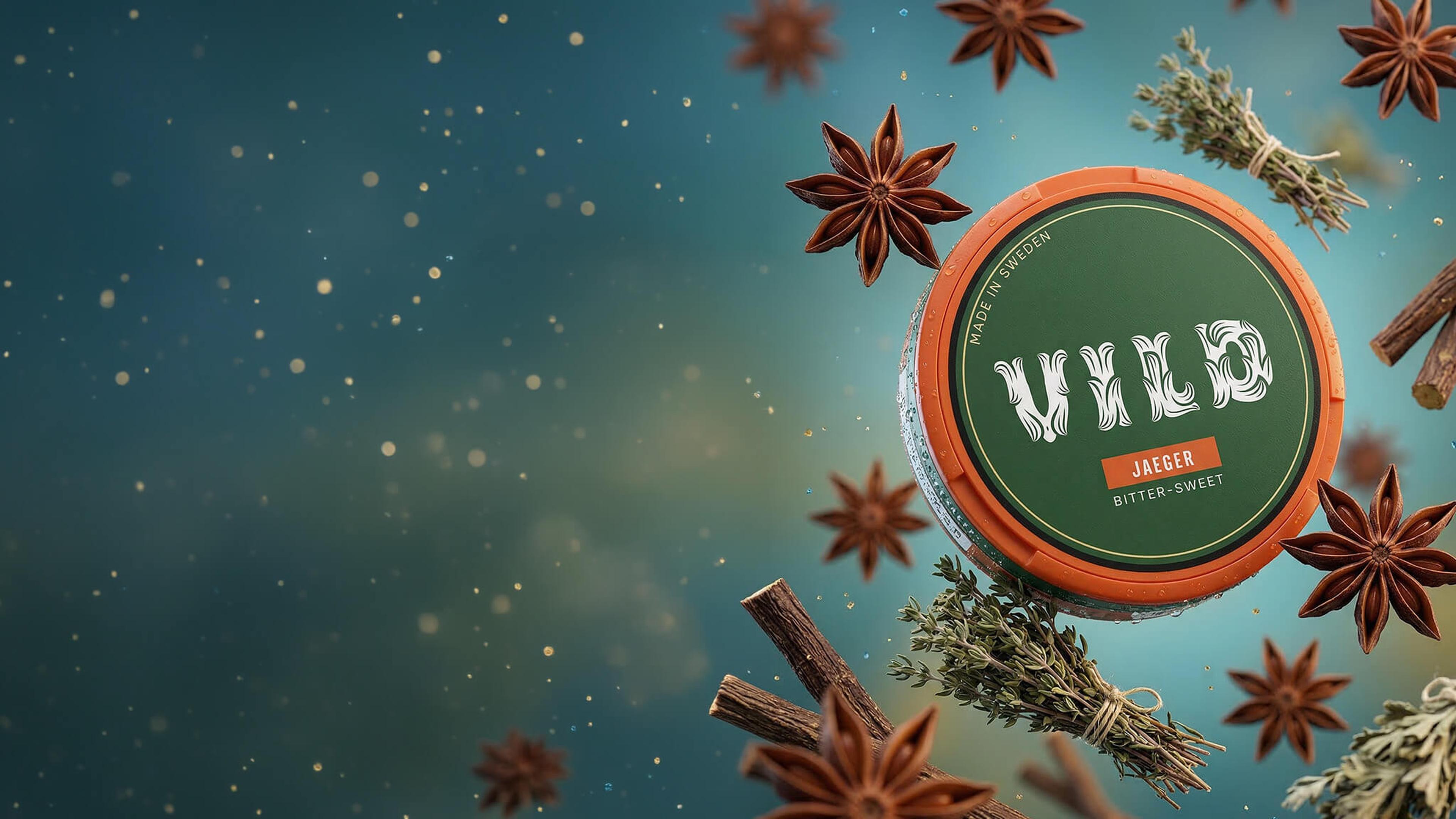 A green Wild Jaeger tin surrounded by star anise, cinnamon sticks, and thyme, against a speckled blue background.