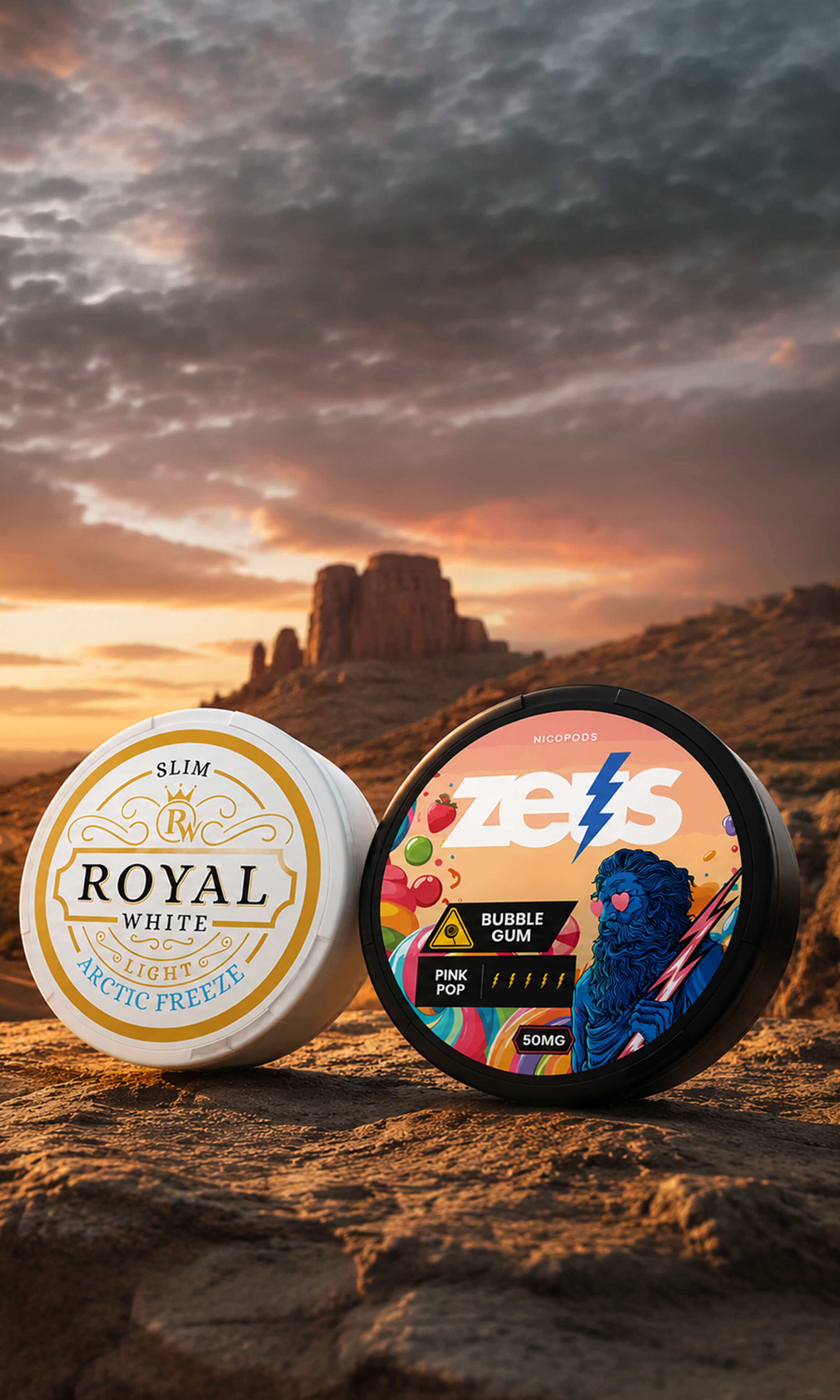 Two tins of nicotine pouches, one labeled Royal White Arctic Freeze, the other Zeus Bubble Gum, on a rock against a dramatic desert sunset.