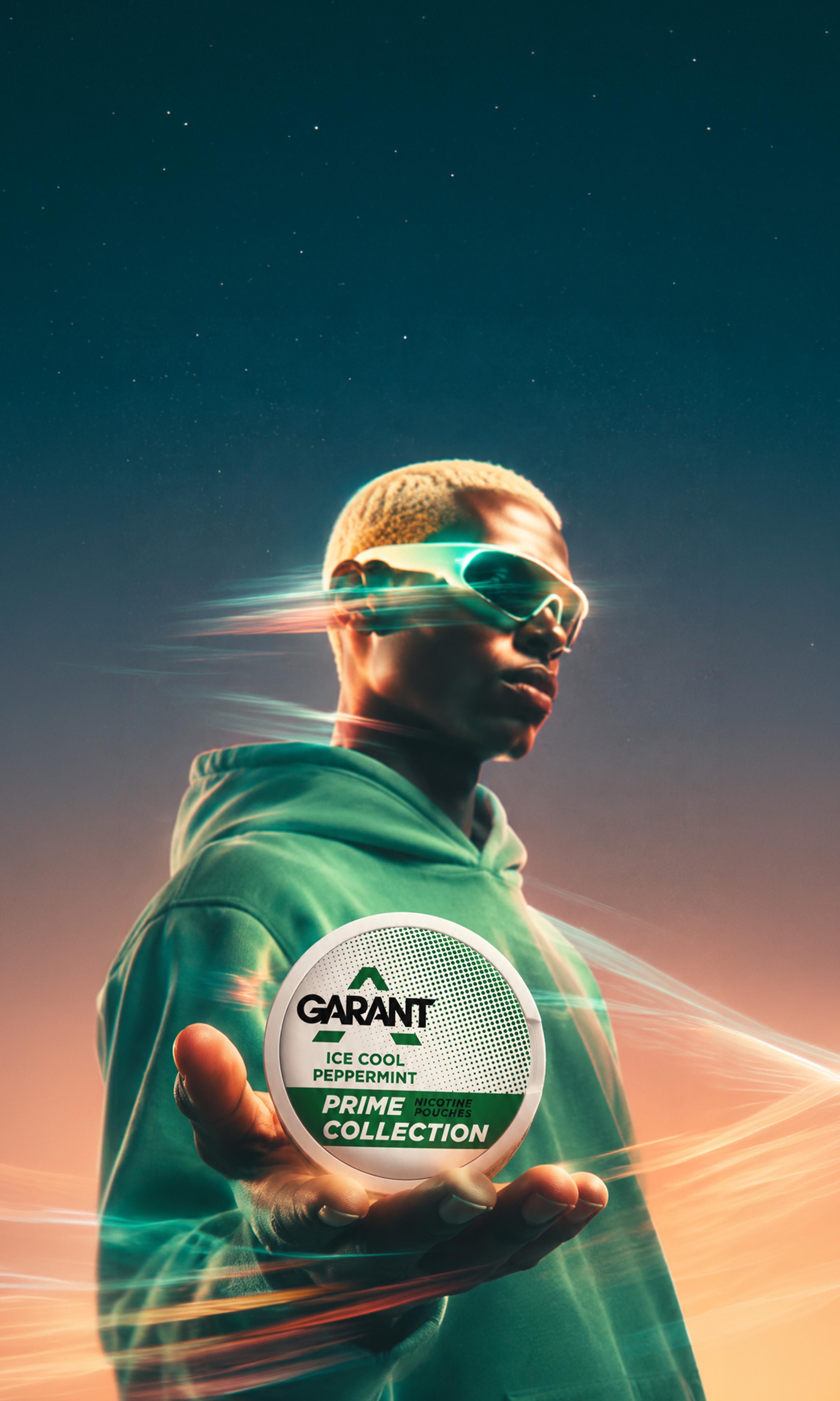 Person in a green hoodie and sunglasses holds a Garant Ice Cool Peppermint nicotine pouch against a colorful, dynamic background.