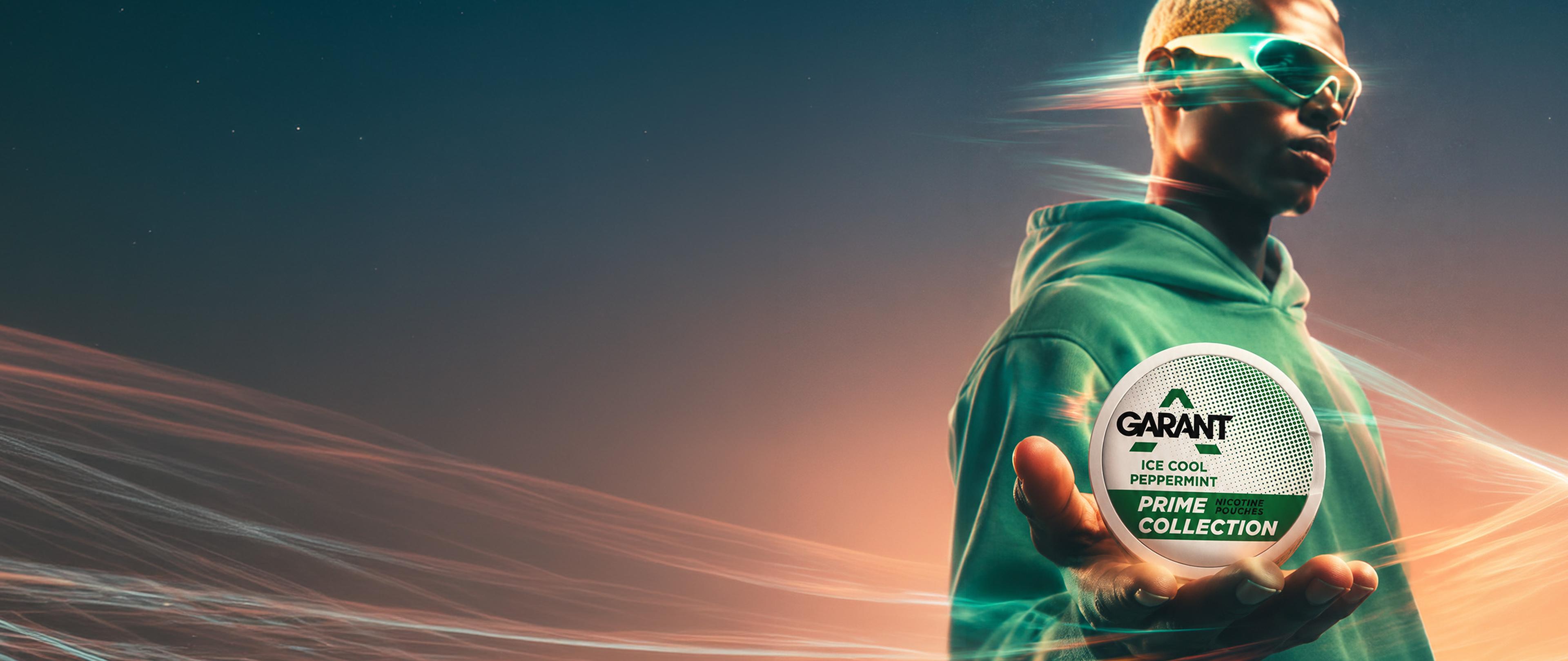 A person in a green hoodie and futuristic sunglasses holds a can labeled "Garant Ice Cool Peppermint Prime Collection" against a dynamic background.