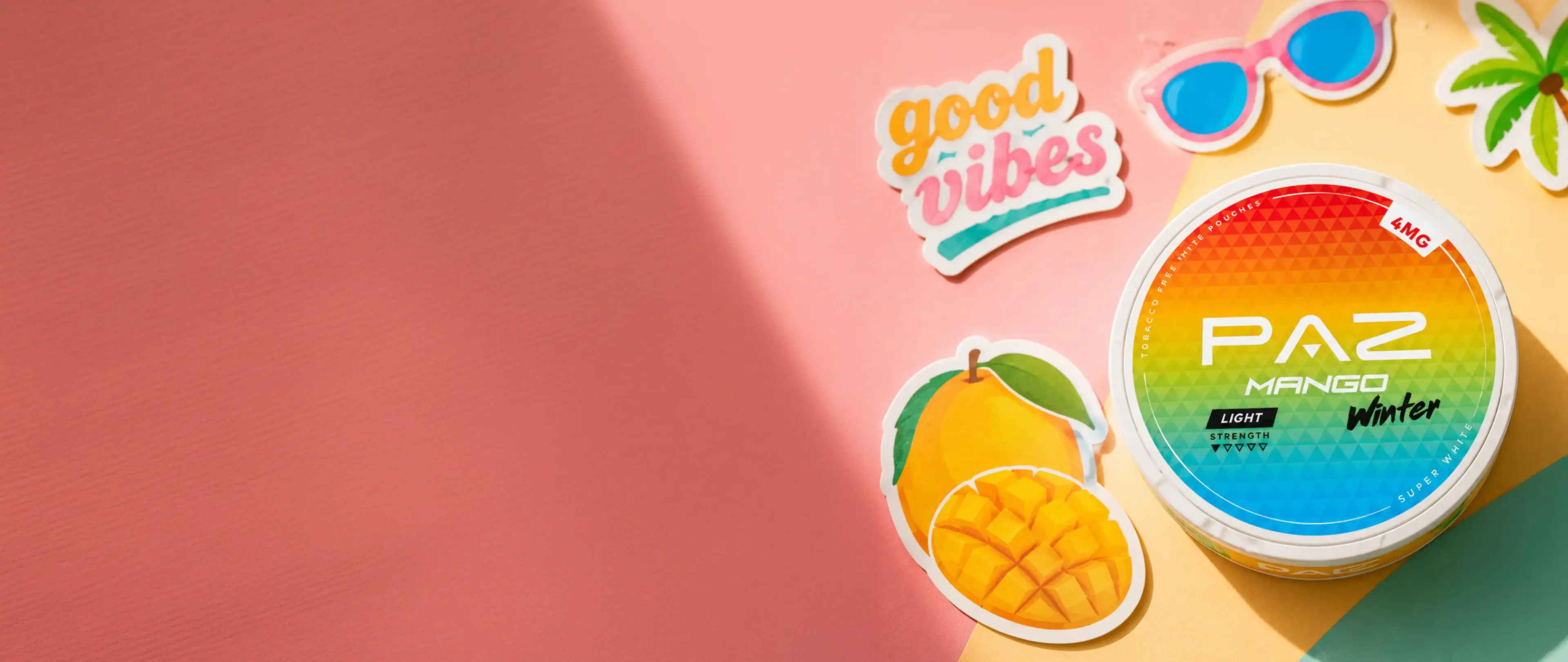 Colorful PAZ Mango Winter snus tin on pink surface with stickers of "good vibes," mango, sunglasses, and palm tree.