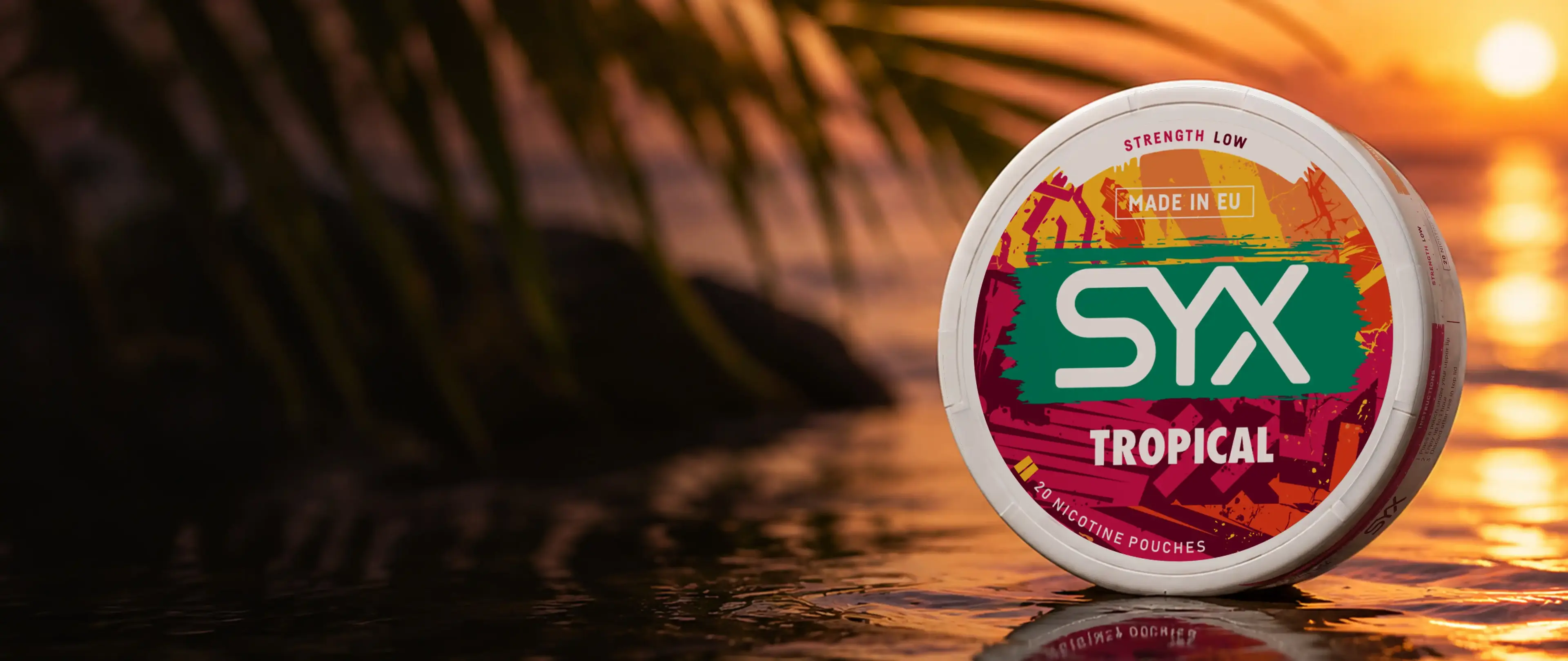 SYX Tropical nicotine pouches container on wet surface with palm leaves, vibrant colors, and warm sunset background.