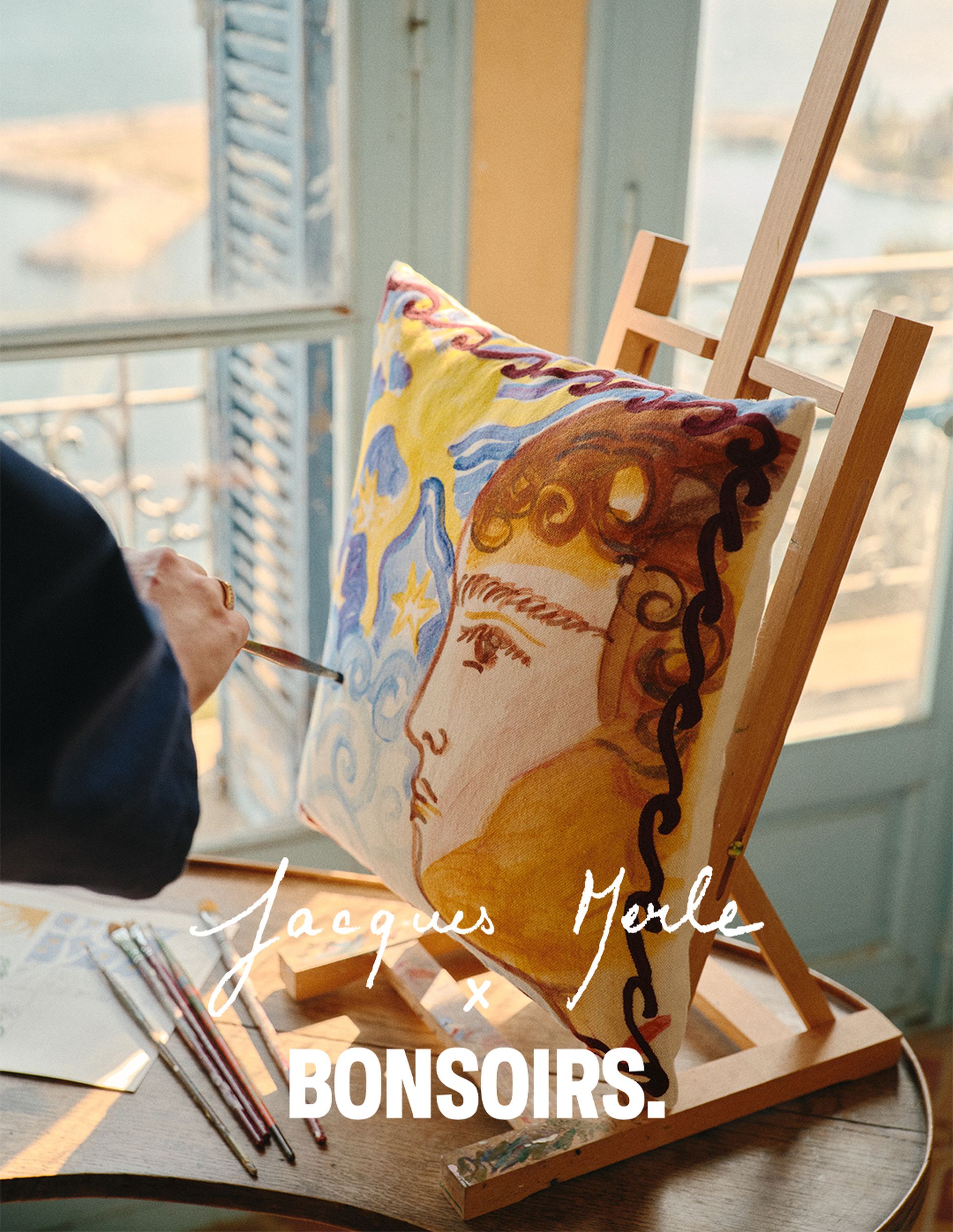 Un artiste peint un portrait saisissant sur un oreiller, représentant un visage orné de motifs tourbillonnants, près d'une fenêtre ouverte donnant sur la mer.