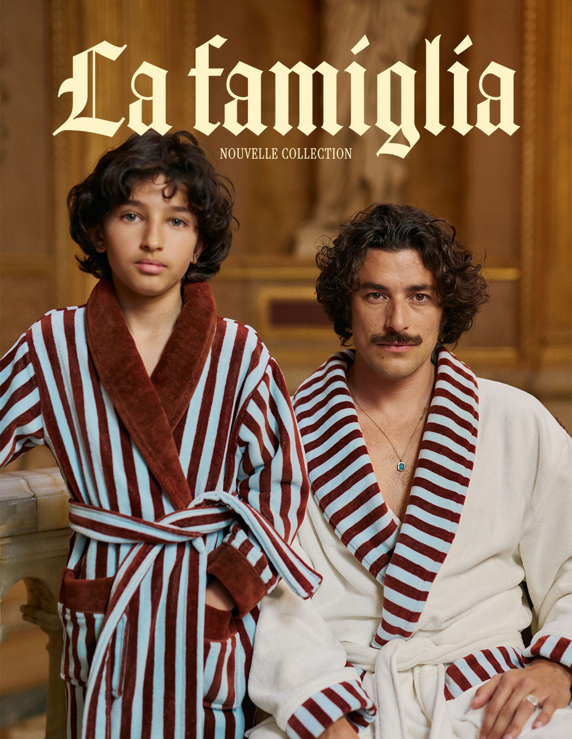 Deux personnes vêtues de peignoirs rayés, l'une de rouge et bleu, l'autre de rouge et blanc, dans un décor somptueux. Le texte « La famiglia Nouvelle Collection » figure au-dessus.