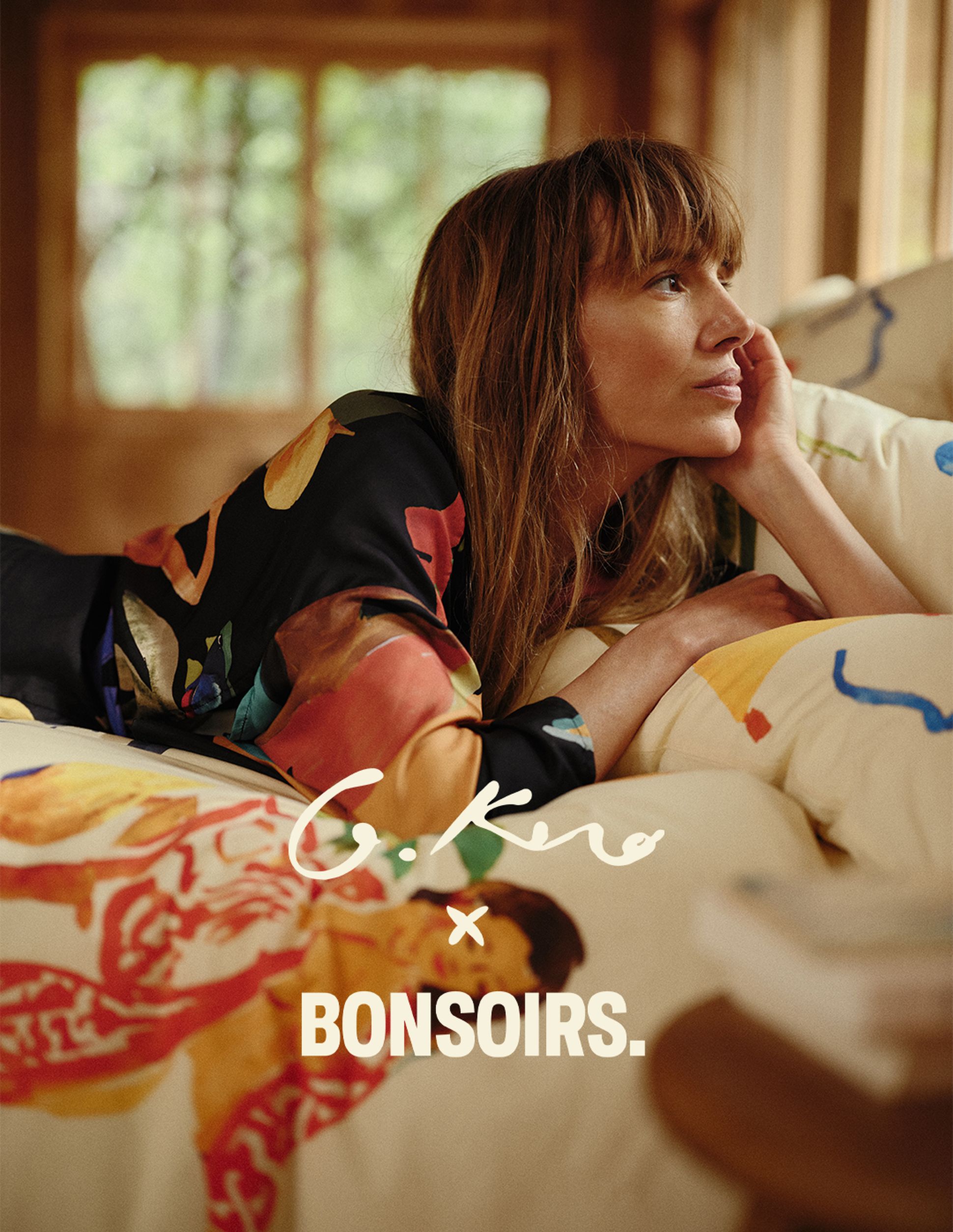 Une femme vêtue d'une robe colorée est allongée sur un lit à motifs, le regard pensif. Légende : « G.Kero x Bonsoirs ».