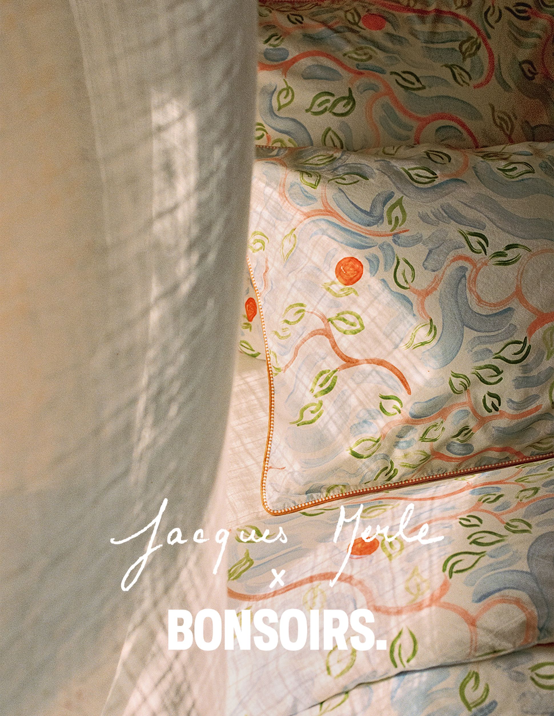 Une parure de lit colorée aux motifs floraux, baignée d'une lumière douce. Une inscription indique « Jacques Merle x BONSOIRS ».