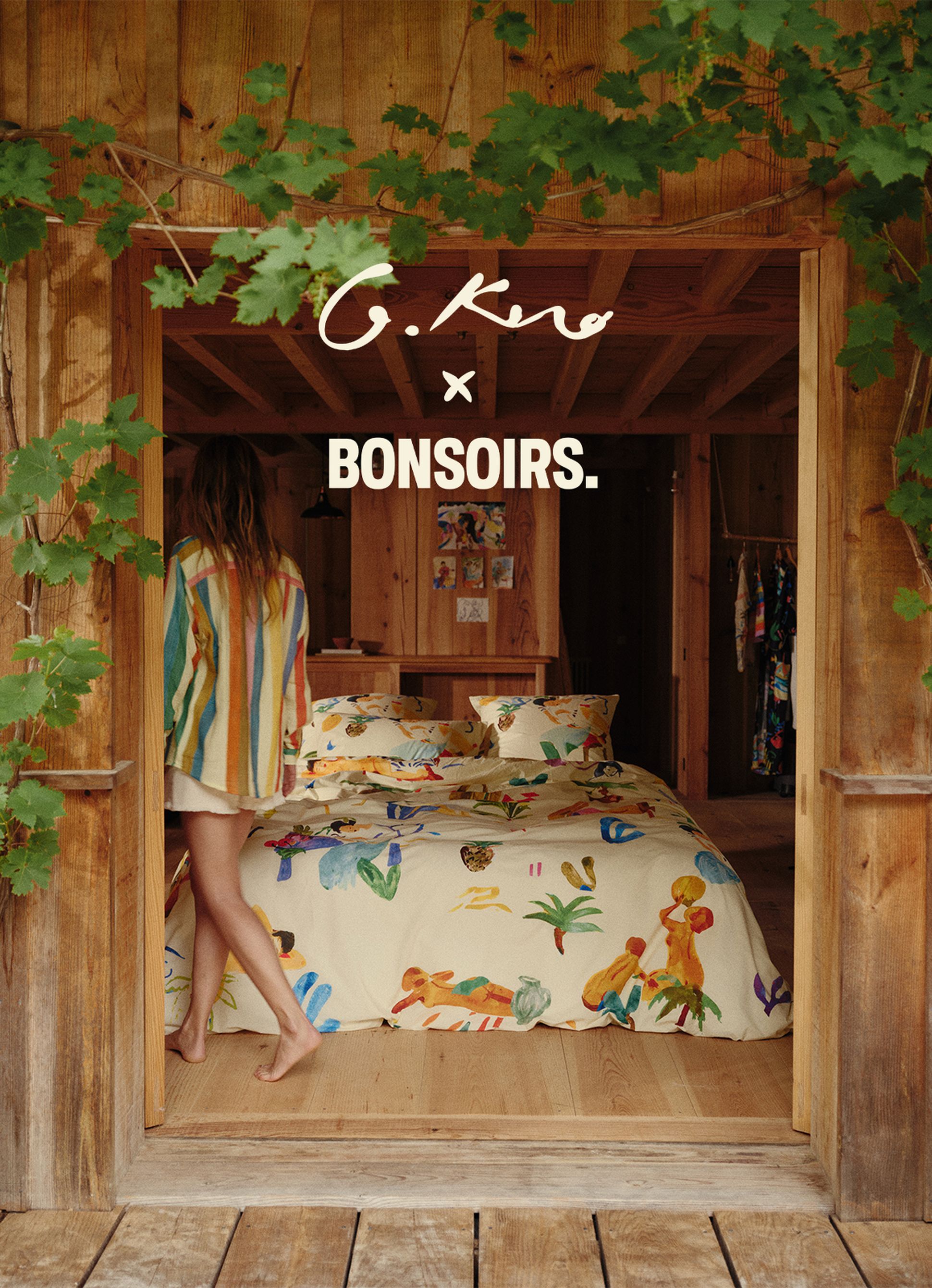 Une femme vêtue d'un t-shirt coloré se tient debout dans une pièce rustique en bois, avec une literie aux couleurs vives. Des feuilles encadrent la scène. On peut lire « G. Kero x Bonsoirs ».
