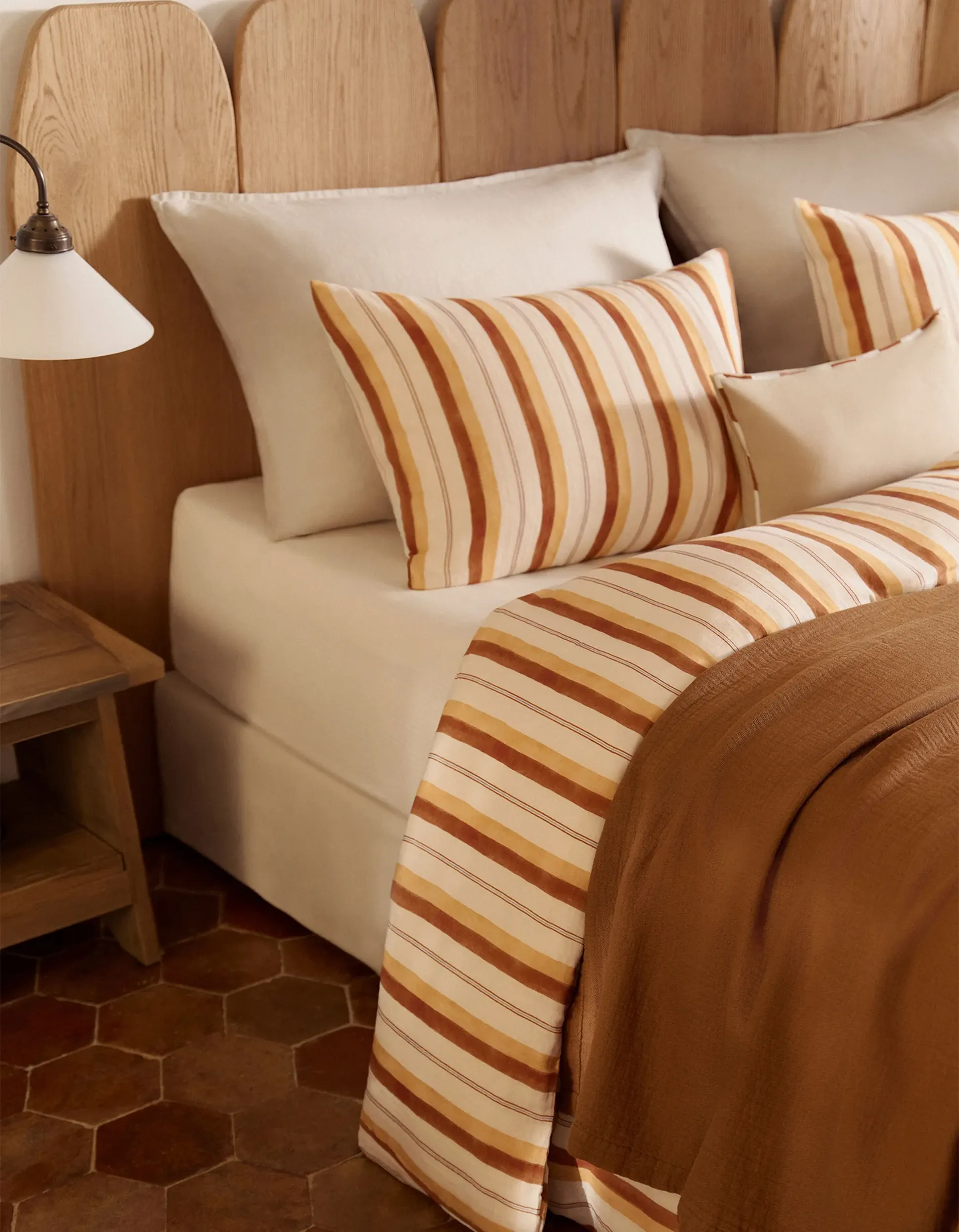 Lit avec parure Rayure Caramel et Ocre, avec couvre-lit Caramel et coussins décoratifs naturels