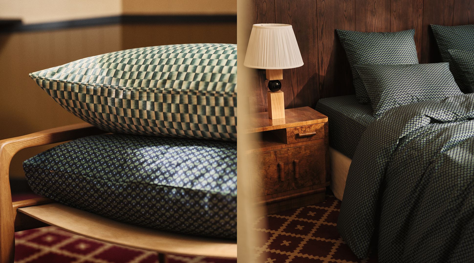 La photo montre une pile de coussins à motifs posés sur une chaise, ainsi qu'un lit recouvert d'une parure de lit aux motifs assortis, à côté d'une table de chevet en bois sur laquelle est posée une lampe.