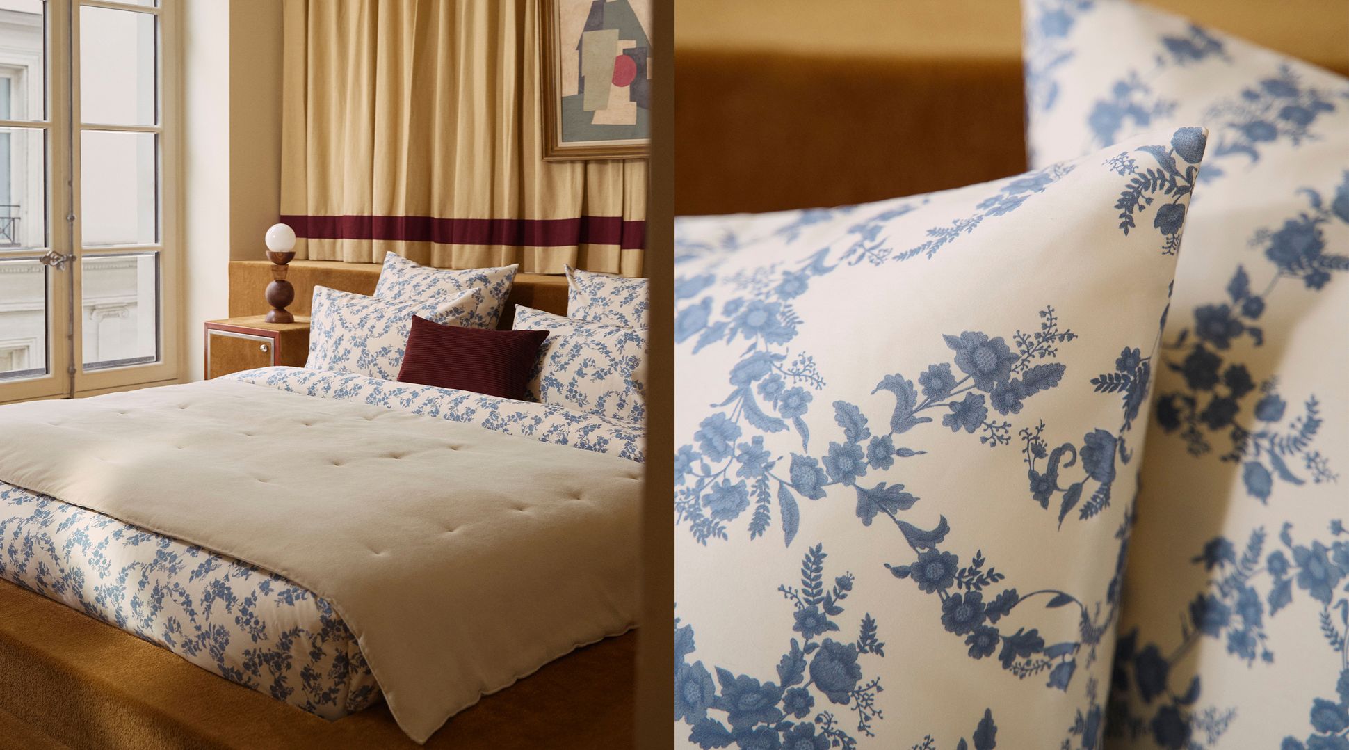 Chambre à coucher avec un lit soigneusement fait, une literie à motifs floraux bleus, un coussin décoratif marron, une grande fenêtre et des œuvres d'art accrochées au mur.