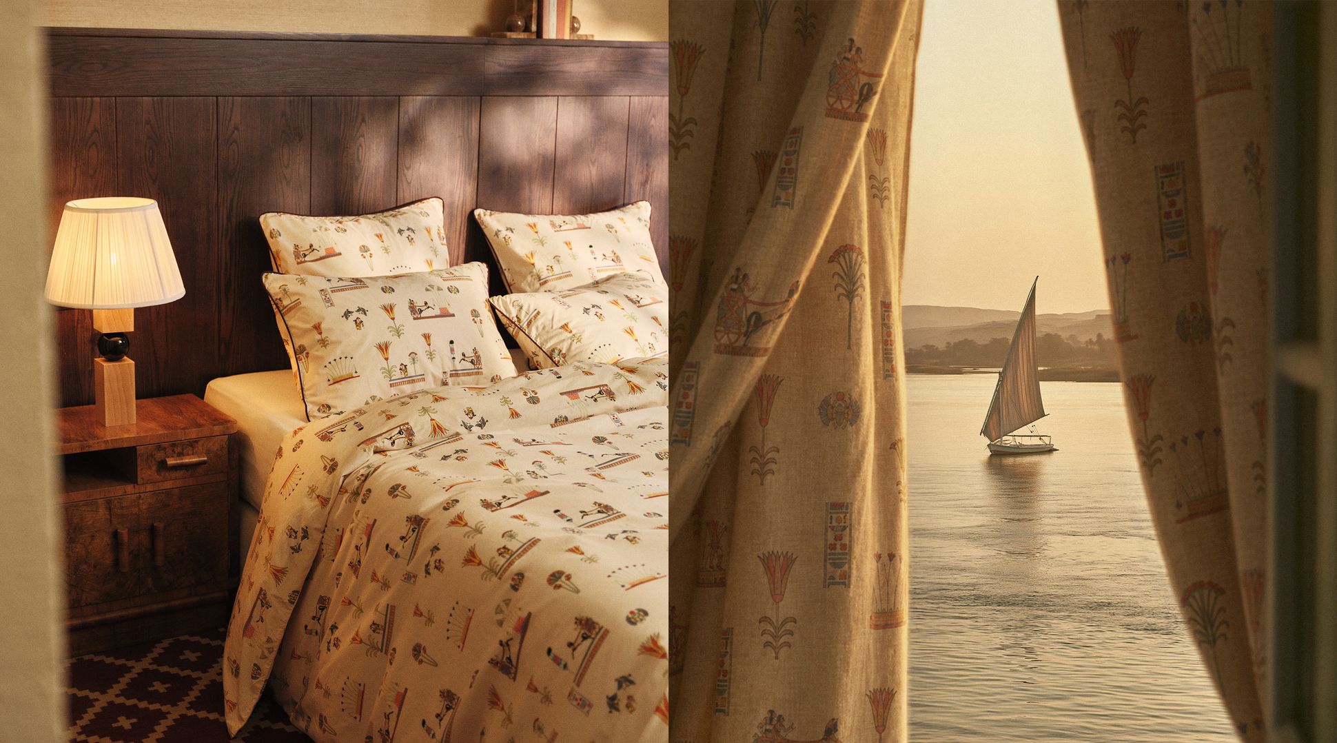 A cozy bedroom with Egyptian-themed bedding, warm lighting from a lamp, and a window view of a sailboat on calm waters during sunset.