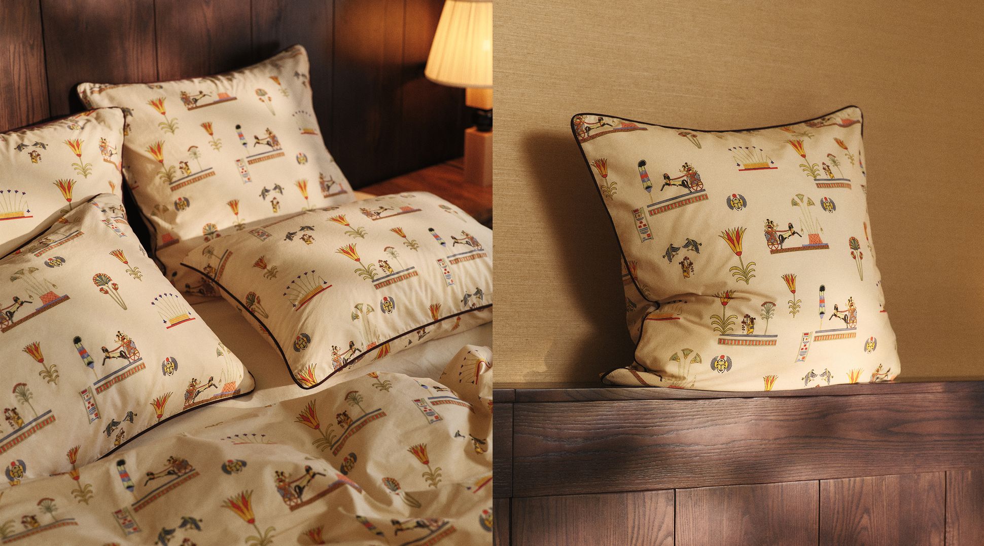 Decorative pillows with an Egyptian motif featuring ancient designs set on a wooden bed, next to a warm-lit lamp.