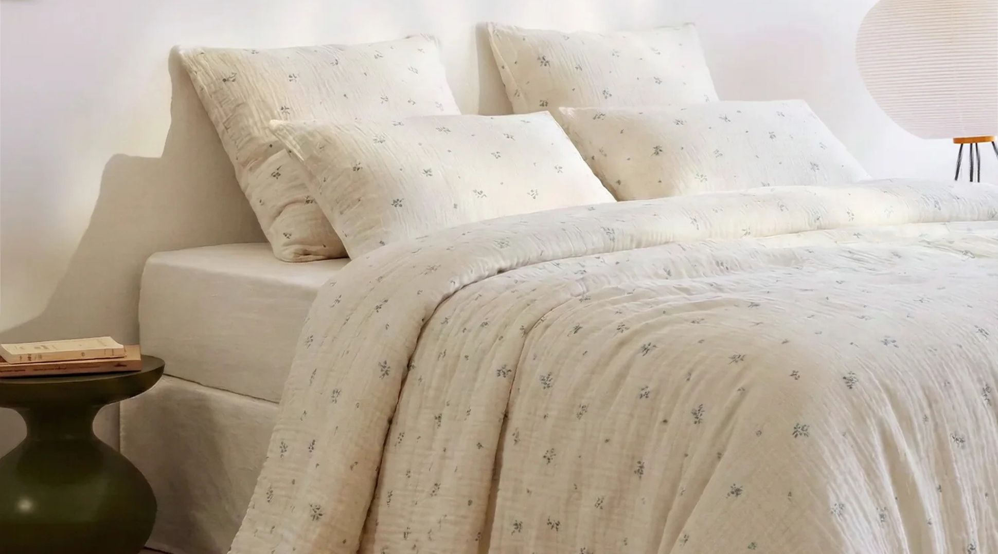 Lit avec draps et oreillers blancs avec des petits motifs à fleurs