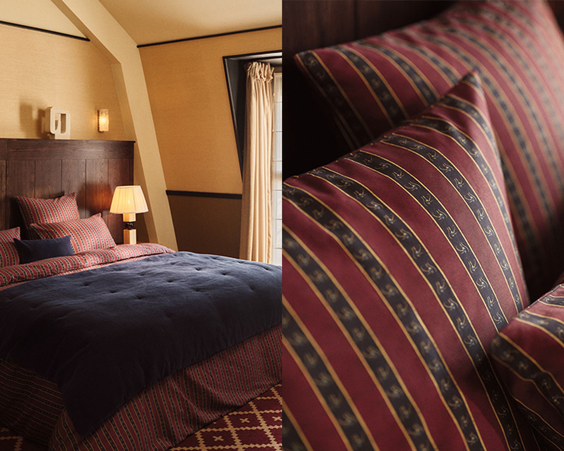 Cozy bedroom with a dark wood headboard, navy bedding, and patterned pillows. A lamp and window with beige curtains are also visible.