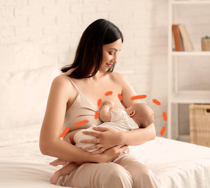 mamma che allatta un neonato seduta sul letto