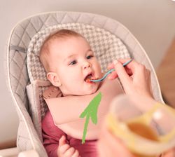 bambino seduto sul seggiolone che viene imboccato