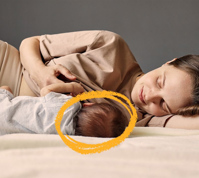 mamma-che-allatta-il-neonato-sdraiato-accanto-a-lei