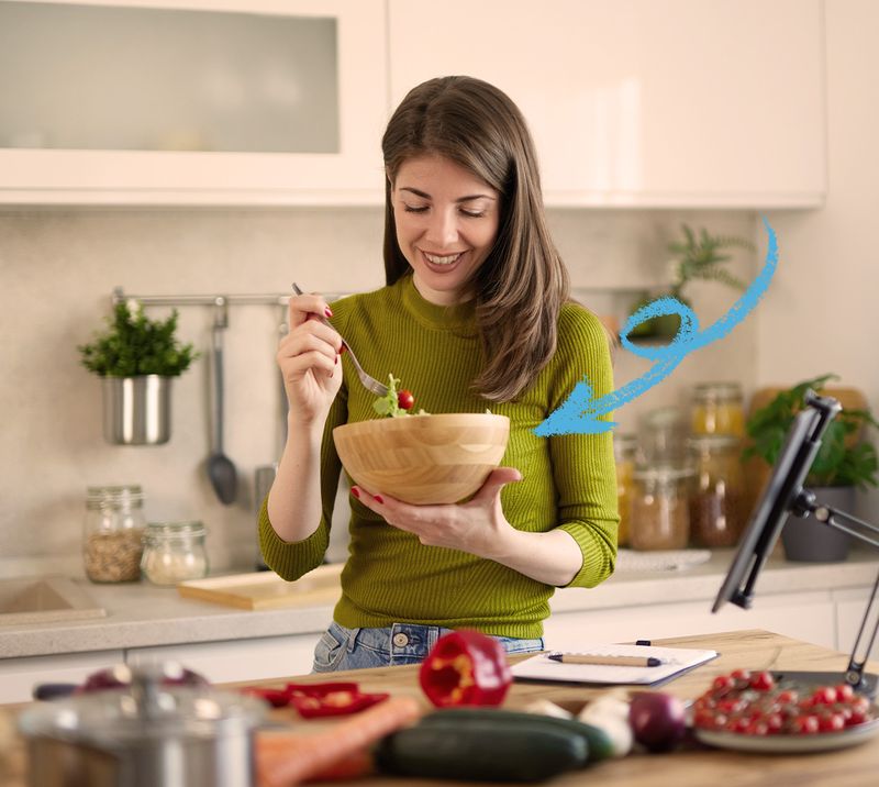 giovane donna sorridente che mangia un insalata