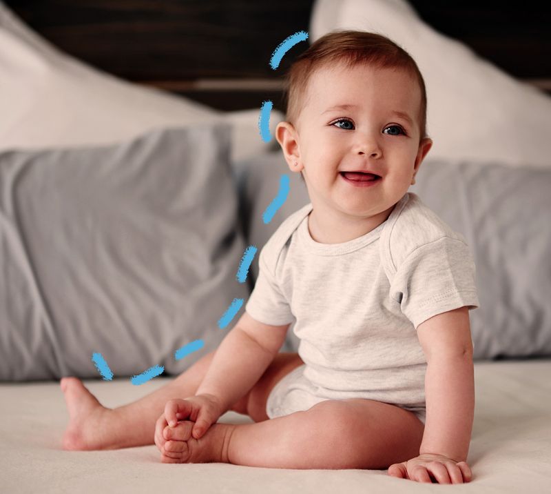 bambino sorride seduto su un letto